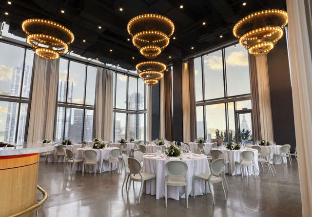 The Loft wedding venue at Virgin Hotels New York with chic lighting and large windows offering city views.