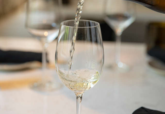 Wine being poured into a glass at Virgin Hotels.