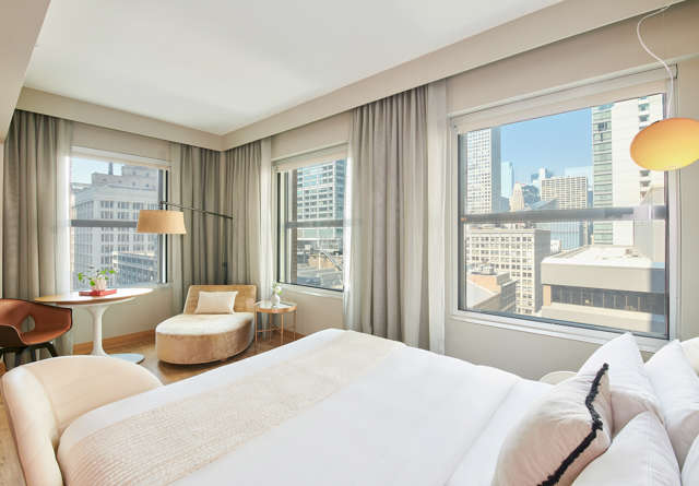 Grand Chamber King room with luxurious furnishings and a city view inside Virgin Hotels Chicago.
