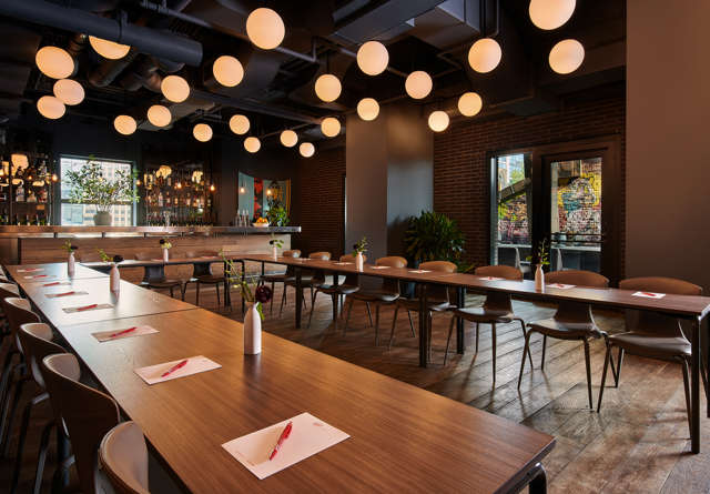 Modern meeting room with wooden tables, stylish chairs, and ambient lighting, ready for a gathering or event.