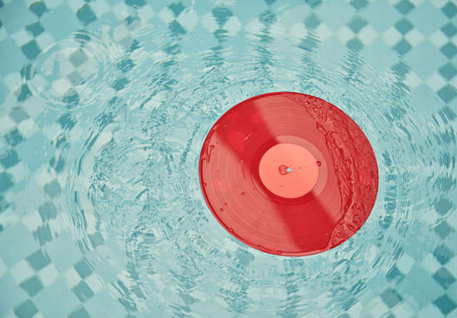 Red DJ vinyl floating in the pool at The Pool Club at Virgin Hotels.