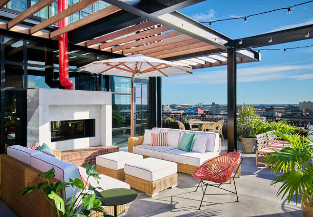 Cozy seating area with a warm fireplace and modern decor, perfect for relaxation at Virgin Hotels.