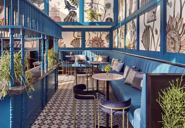 Bar at Virgin Hotels New York with sleek bar stools, modern decor, creating a trendy social spot.